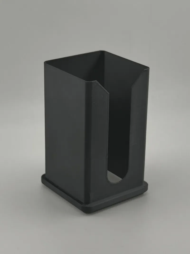 Black 3D printed holder: an open-topped rectangular box with a tall rounded slot cut up the front and a flanged base.