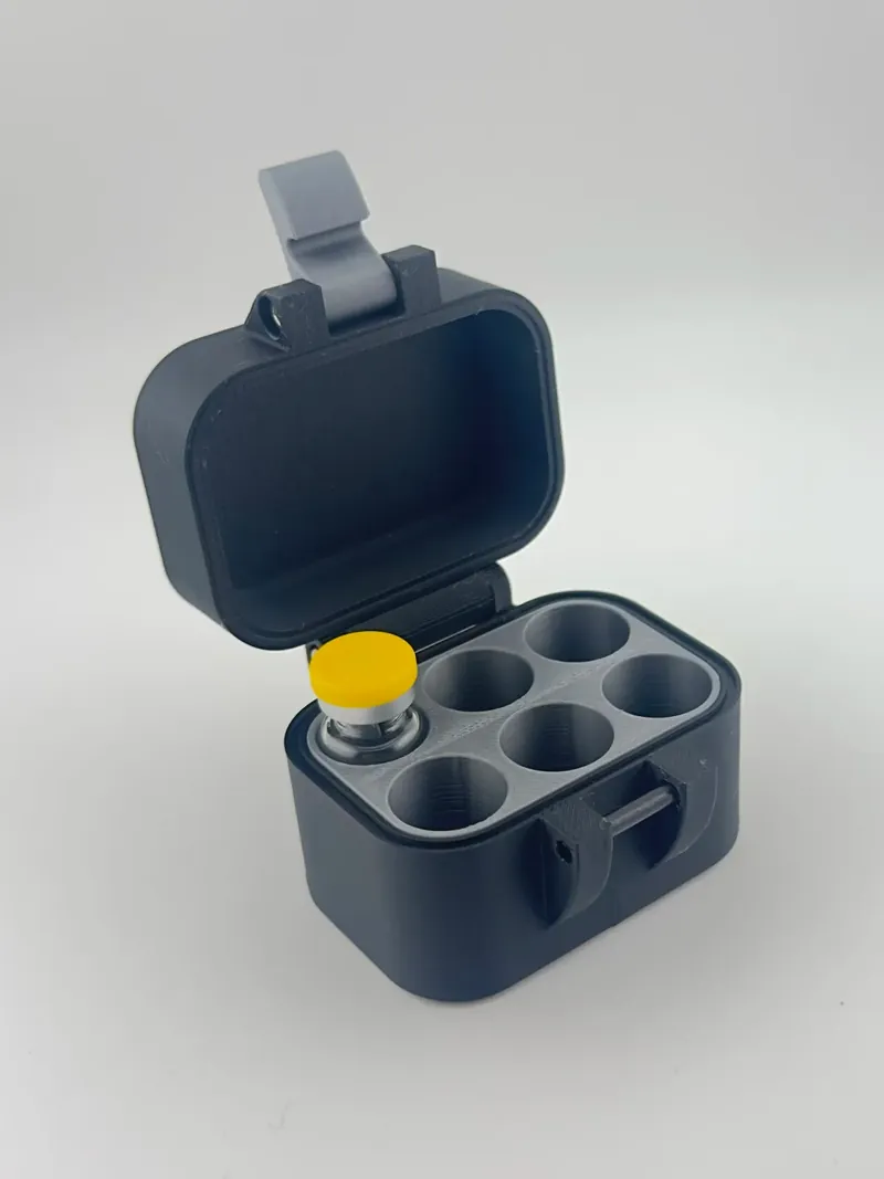 Black hinged case that holds vials, with a gray six-well insert, one well holding a yellow-capped vial, and a pin latch on the front.