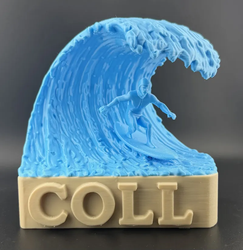 3D printed 'COLL' nameplate with a detailed blue ocean wave and surfer rising from a tan lettered base.
