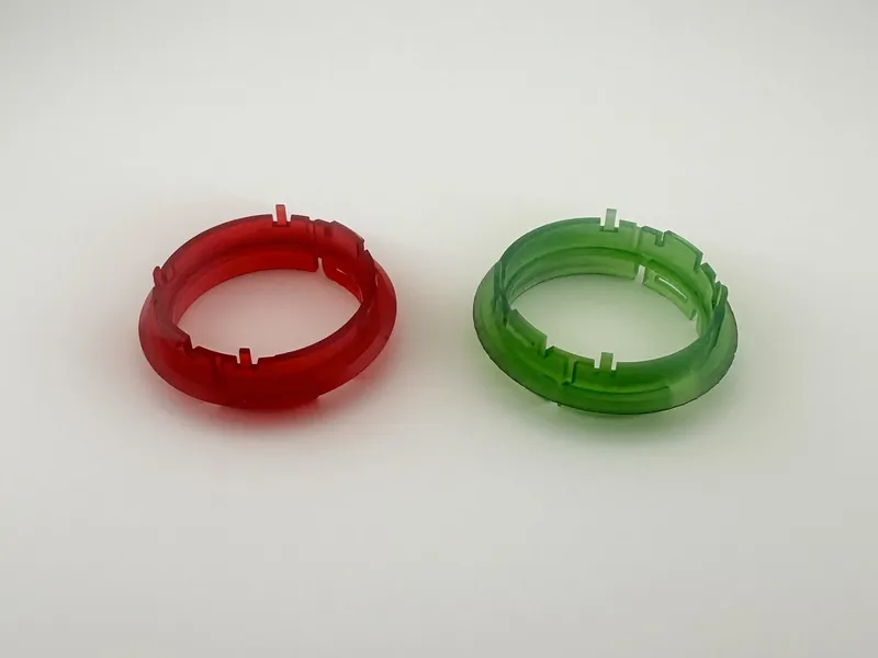 Replacement knob rings that change the color of the OEM dashboard lights: two translucent 3D printed rings, one red and one green, each with notched tabs around its rim.